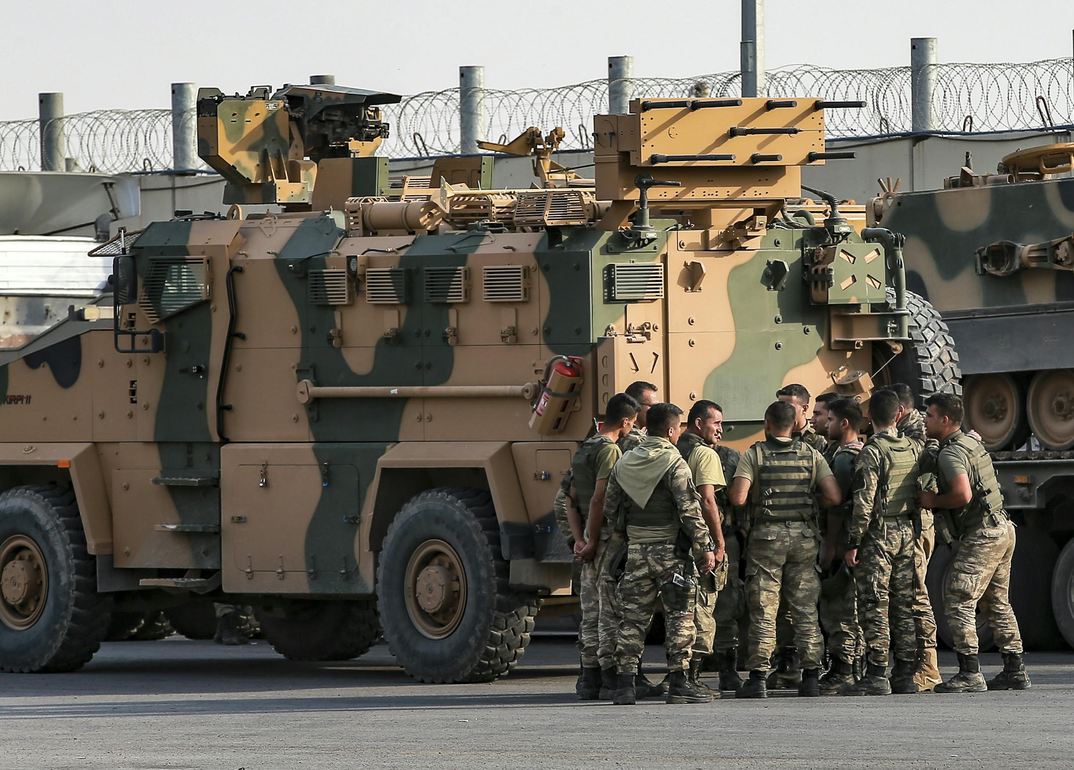 Turkish soldiers prepare to enter Syria aboard an armoured personnel carrier at the border with Syria in Karkamis, Gaziantep province, southeastern Turkey, Tuesday, Oct. 15, 2019. Turkey defied growing condemnation from its NATO allies to press ahead with its invasion of northern Syria on Tuesday, shelling suspected Kurdish positions near the border amid reports that Syrian Kurds had retaken a key town. (AP Photo/Emrah Gurel) ORG XMIT: XLP109