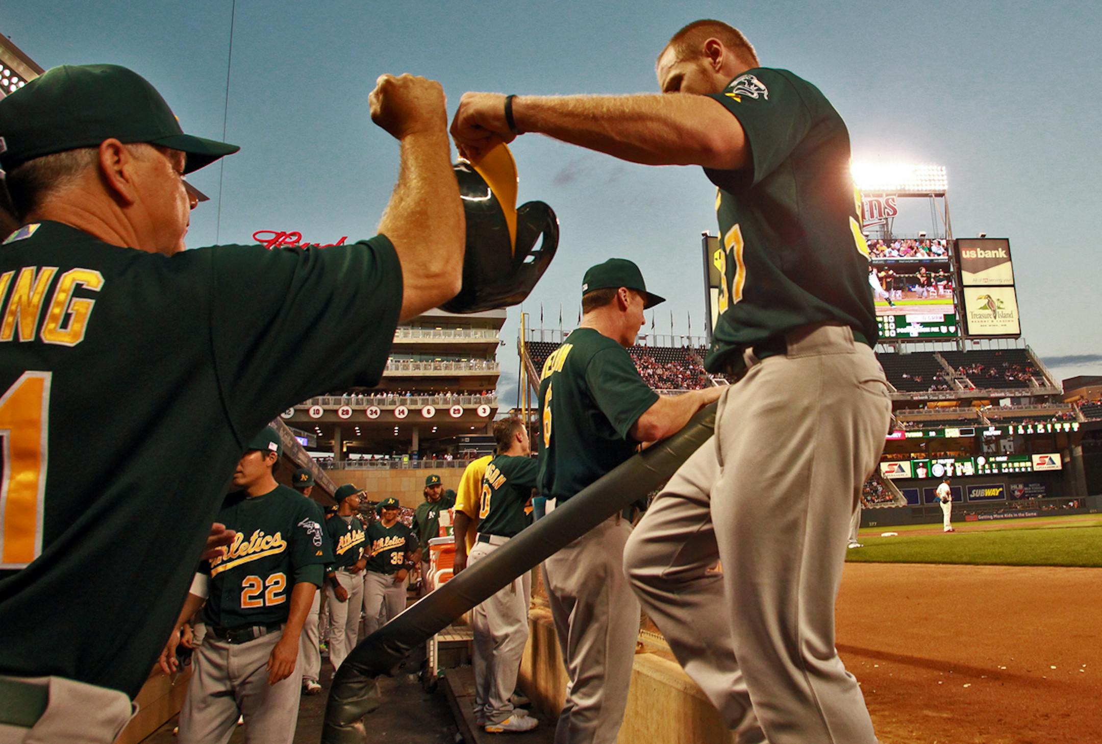 Minnesota Twins vs. Oakland Athletics. Oakland's Brandon Moss, right, was congratulated by teammates in the dugout after he scored a run in the first inning. (MARLIN LEVISON/STARTRIBUNE(mlevison@startribune.com)
