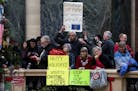Protestors at the state Capitol in Madison hold up signs on Tuesday, Dec. 4, 2018, as the Wisconsin State Assembly debates a series of bills that woul