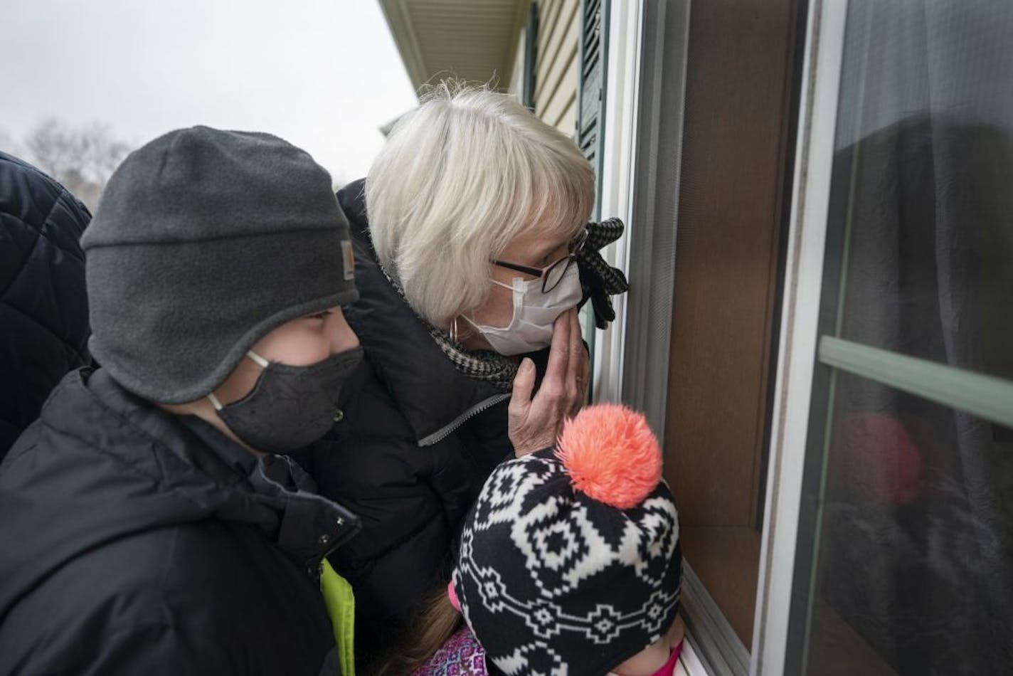 Katherine Berg with husband Brian Berg and grandkids Cullen Beeler, 8, and Laney Beeler, 5, blew a kiss to her mom, 99-year-old Eleanor Murray, who is staying at the Prairie Senior Cottages in Isanti, Minn.