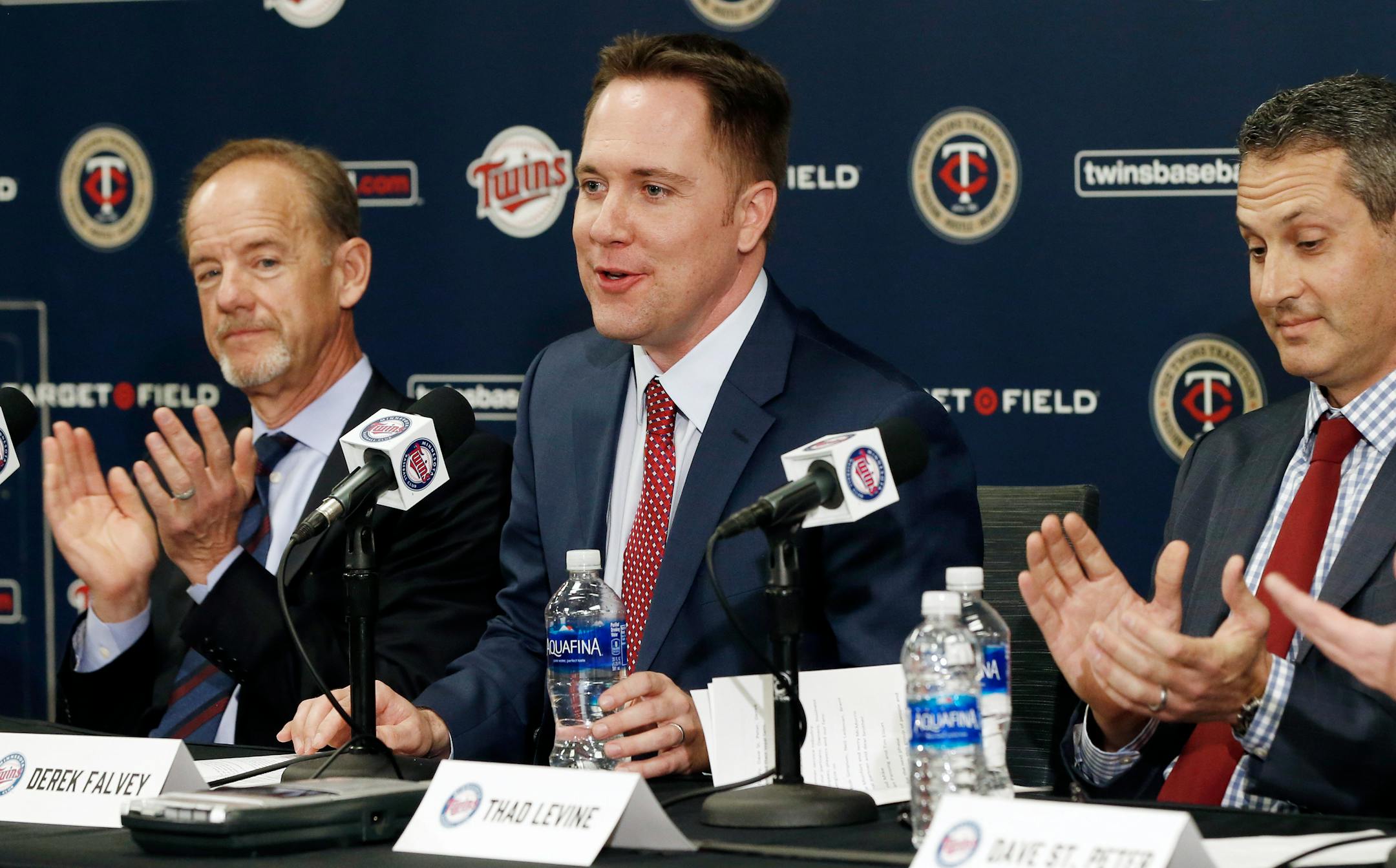 Minnesota Twins owner, Jim Pohlad, left, and new general manager Tad Levine, right, applaud the introduction of new chief baseball officer Derek Falvey, center, during introductions Monday, Nov. 7, 2016 in Minneapolis. (AP Photo/Jim Mone) ORG XMIT: MIN2016111122491956