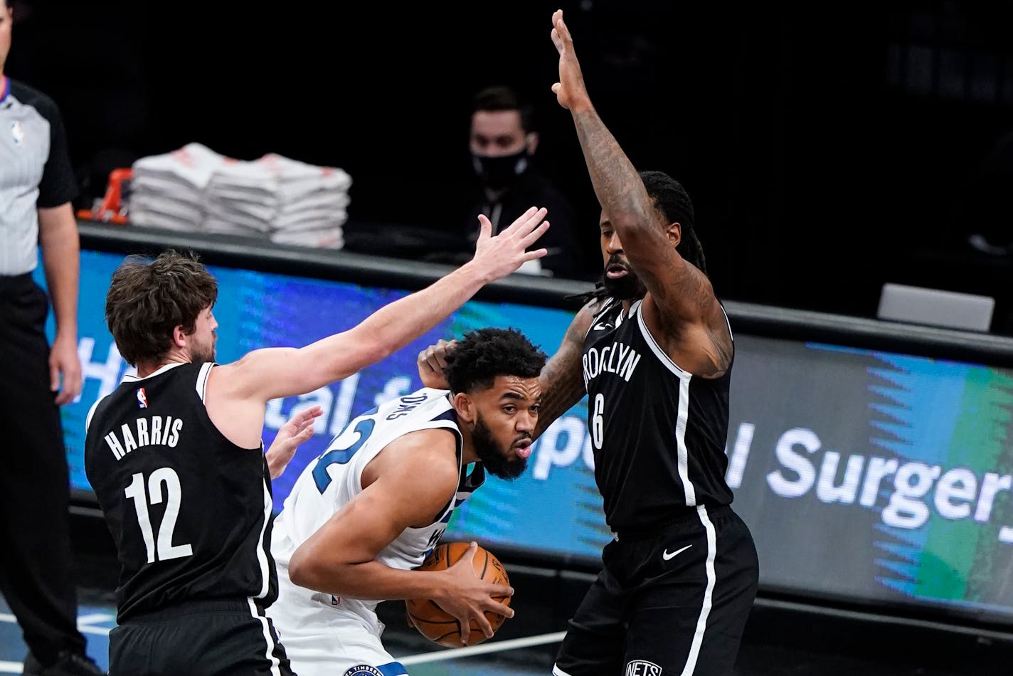 Minnesota Timberwolves' Karl-Anthony Towns (32) is defended by Brooklyn Nets' Joe Harris (12) and DeAndre Jordan during the first half of an NBA basketball game Monday, March 29, 2021, in New York. (AP Photo/Frank Franklin II)