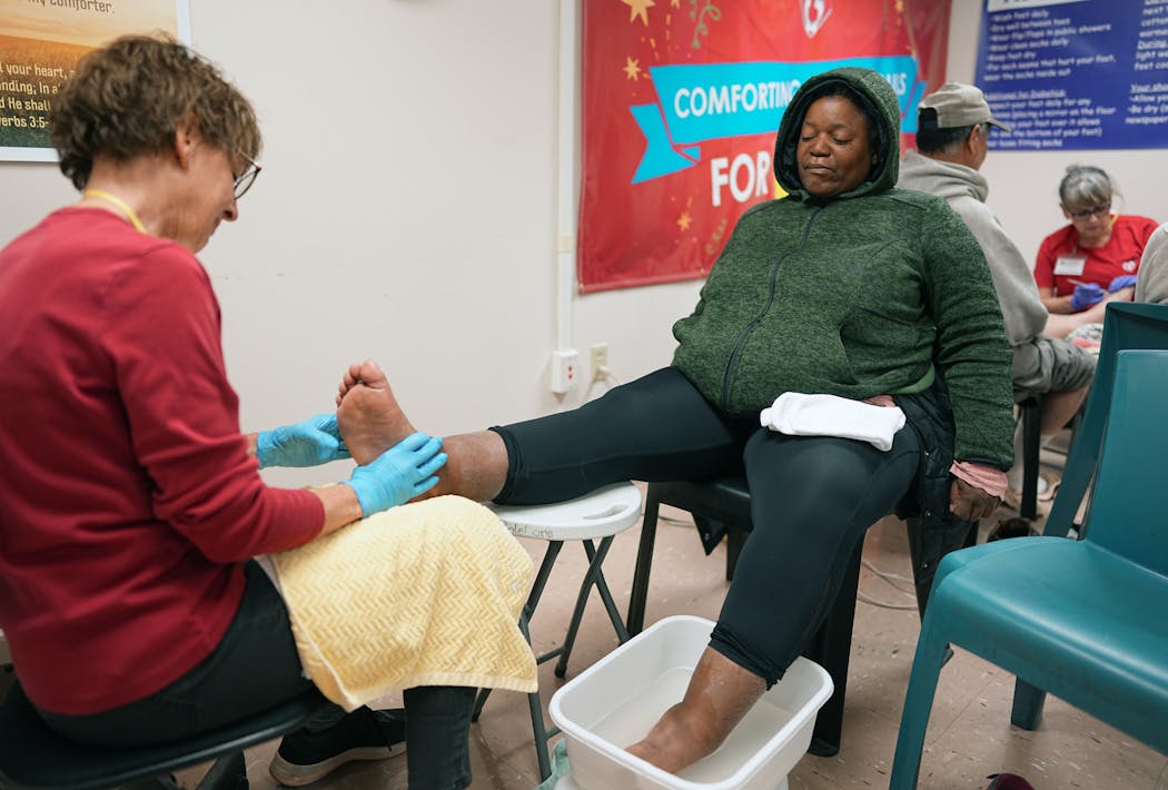 Kathy Jo Bissen, founder of SoleCare for Souls and now a retired volunteer, gives foot care to Lisa Vaughn during a recent visit to the Mary F. Frey  Opportunity Center in Minneapolis. 