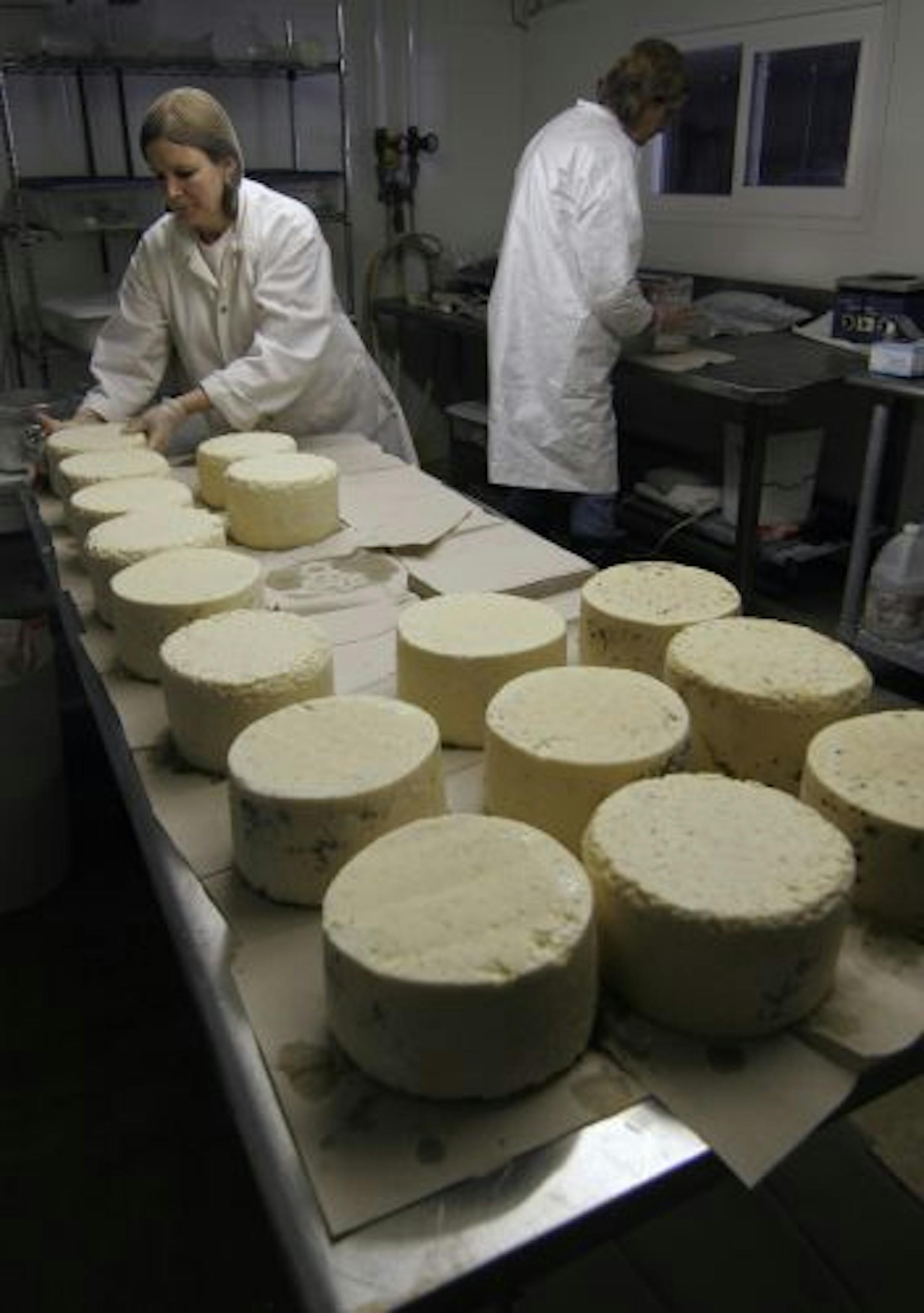 Jodi Ohlsen Read, left, and her sister-in-law, Keri Maros, wrapped wheels of "Big Woods Blue" cheese for shipment to California.