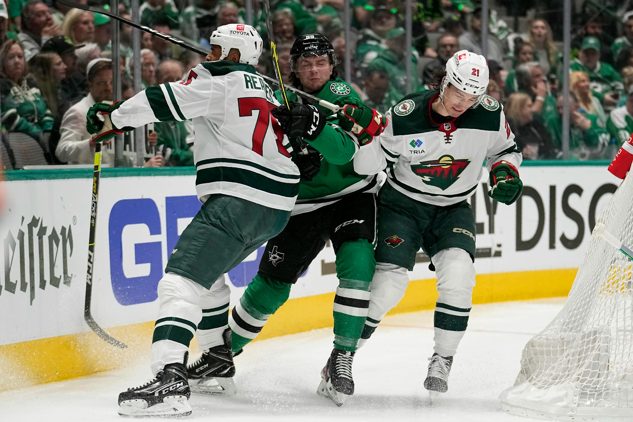 Dallas Stars defenseman Thomas Harley (55) works against Minnesota Wild right wing Ryan Reaves (75) and Brandon Duhaime (21) behind the net in the second period of Game 1.