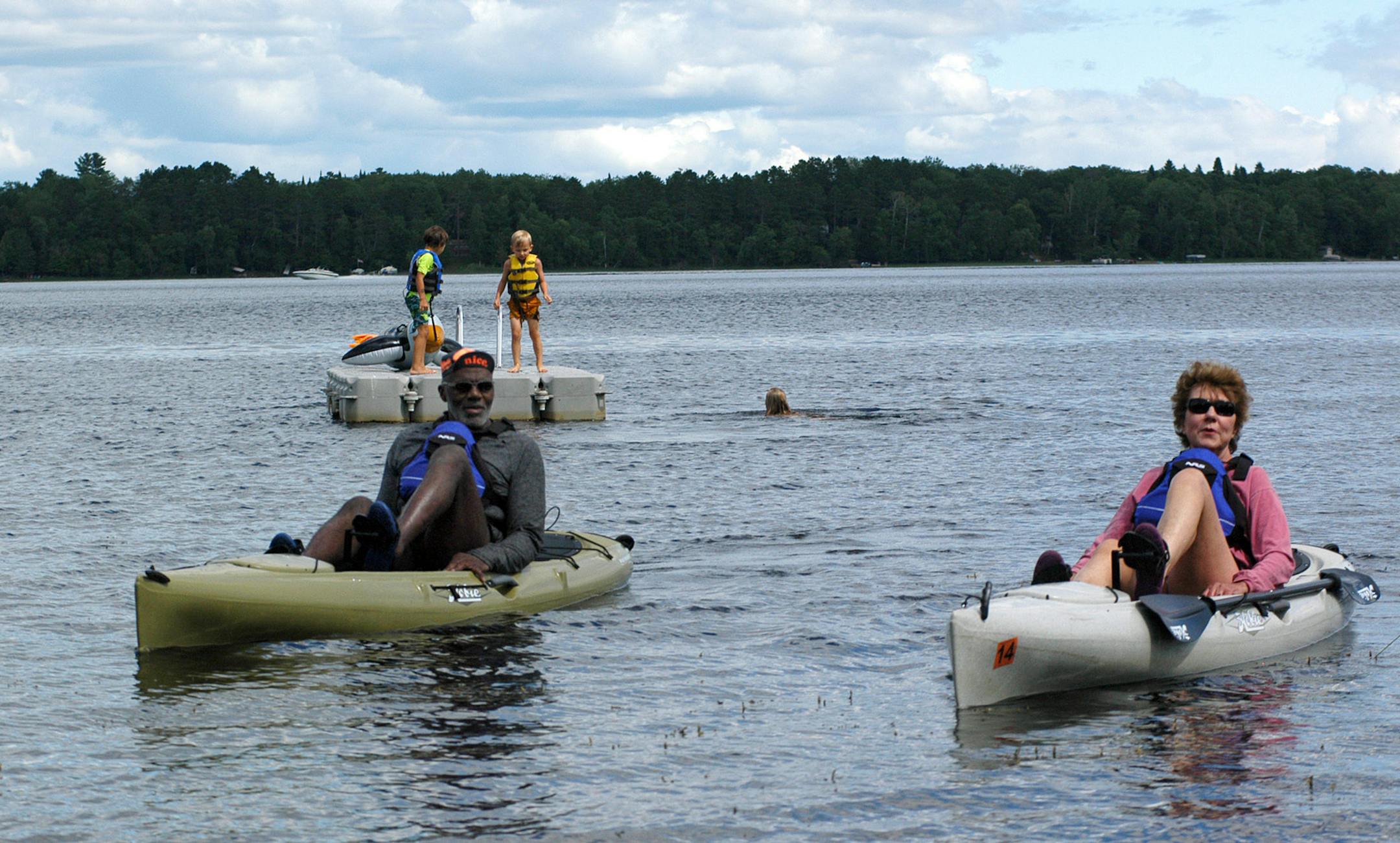 Alan and Diane Page love to kayak with their peddle-style kayaks. Behind them grandkids and friends play on the raft.