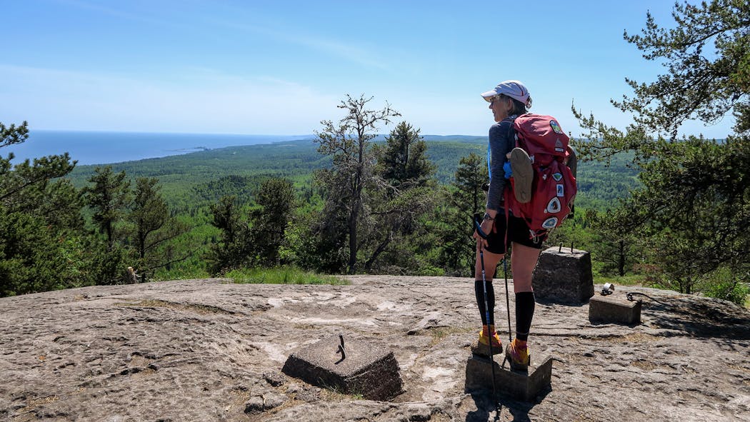 Melanie Radzicki McManus took in the view from the top of Carlton Peak, standing on footings for an old fire tower. Many of these high points along the North Shore are made of igneous rock, compositions of lava that gathered up and solidified millions of years ago.