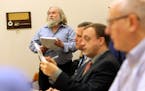 Minneapolis resident Dave Bicking, left, stands to present his concerns during the public invitation portion of the regular monthly board meeting of t