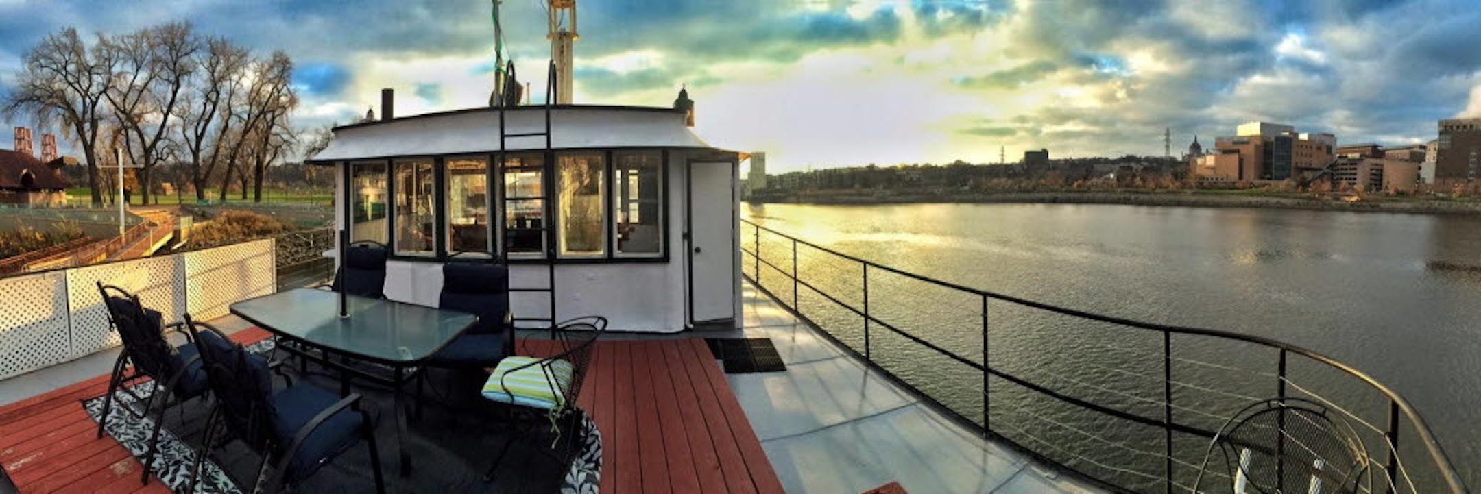 The upper deck of the refurbished towboat that houses the Covington Inn offers sunset Mississippi river views near downtown St. Paul.