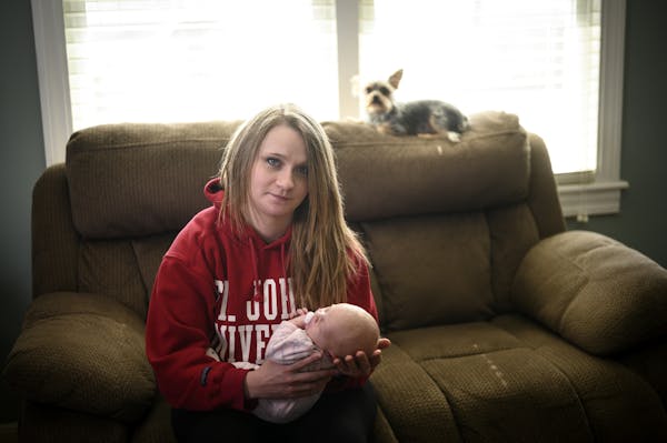 Cody Cuningham sat her with newborn daughter, Grace, and her mom's dog, Mickey, Saturday in her mom's living room in South Haven, Minn.