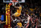 Pharrel Payne (21) of the Minnesota Golden Gophers hangs on the rim after a dunk agains the Ohio State Buckeyes in the second half Thursday, Feb. 22, 