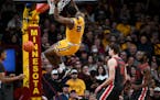 Pharrel Payne (21) of the Minnesota Golden Gophers hangs on the rim after a dunk agains the Ohio State Buckeyes in the second half Thursday, Feb. 22, 