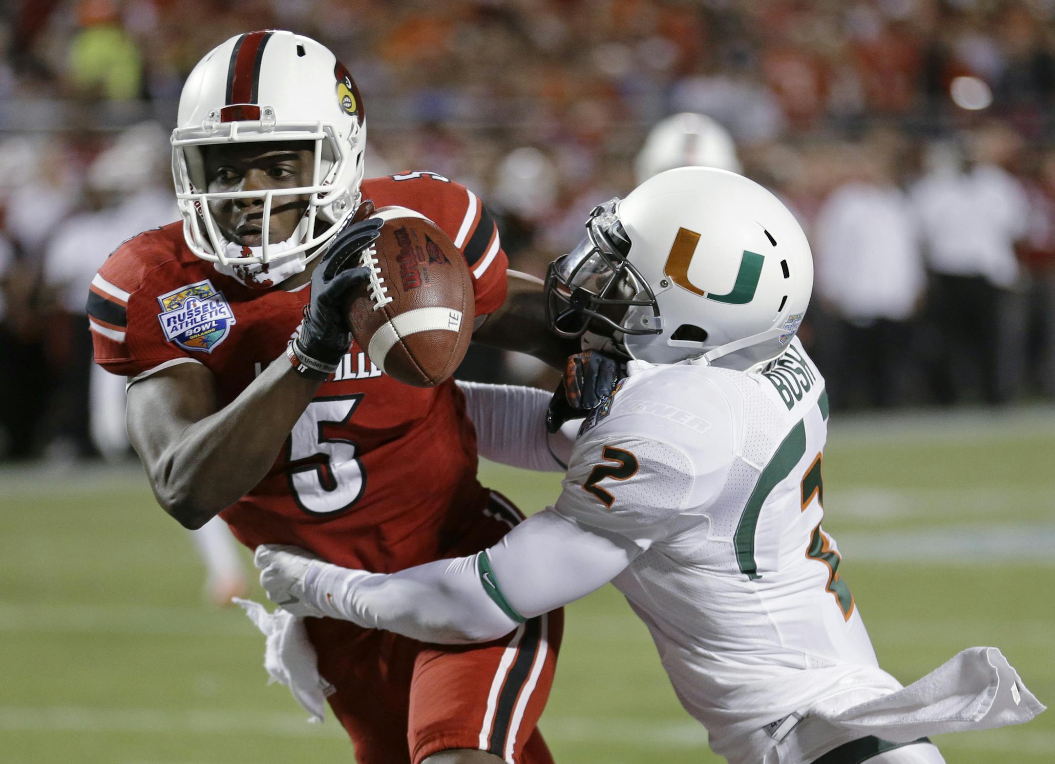 Miami defensive back Deon Bush (2) sacks Louisville quarterback Teddy Bridgewater (5) in the end zone for a safety during the first half of the Russell Athletic Bowl NCAA college football game in Orlando, Fla., Saturday, Dec. 28, 2013. (AP Photo/John Raoux)