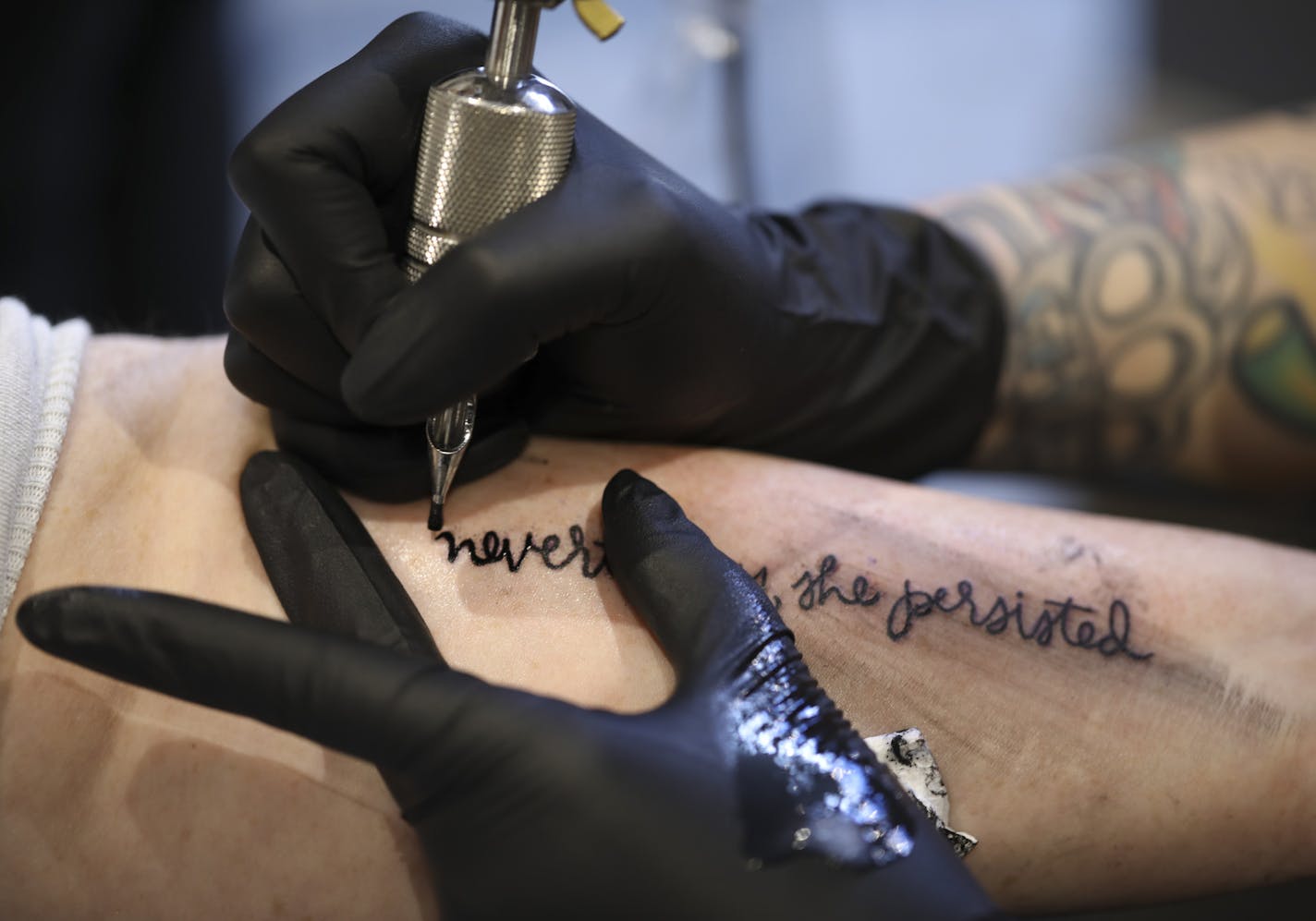 Emily Snow tattooed "nevertheless, she persisted" on Kate O'Reilly Tuesday afternoon at Brass Knuckle Tattoo Studio. It was her first tattoo. ] JEFF WHEELER &#xef; jeff.wheeler@startribune.com What began as in impulsive idea blossomed into something more when Nora McInerny had the idea to get a tattoo of the now infamous quote from Senate Majority Leader Mitch McConnell about Sen. Elizabeth Warren. Thinking other like-minded women might also want to join her, she created a Facebook event that qu