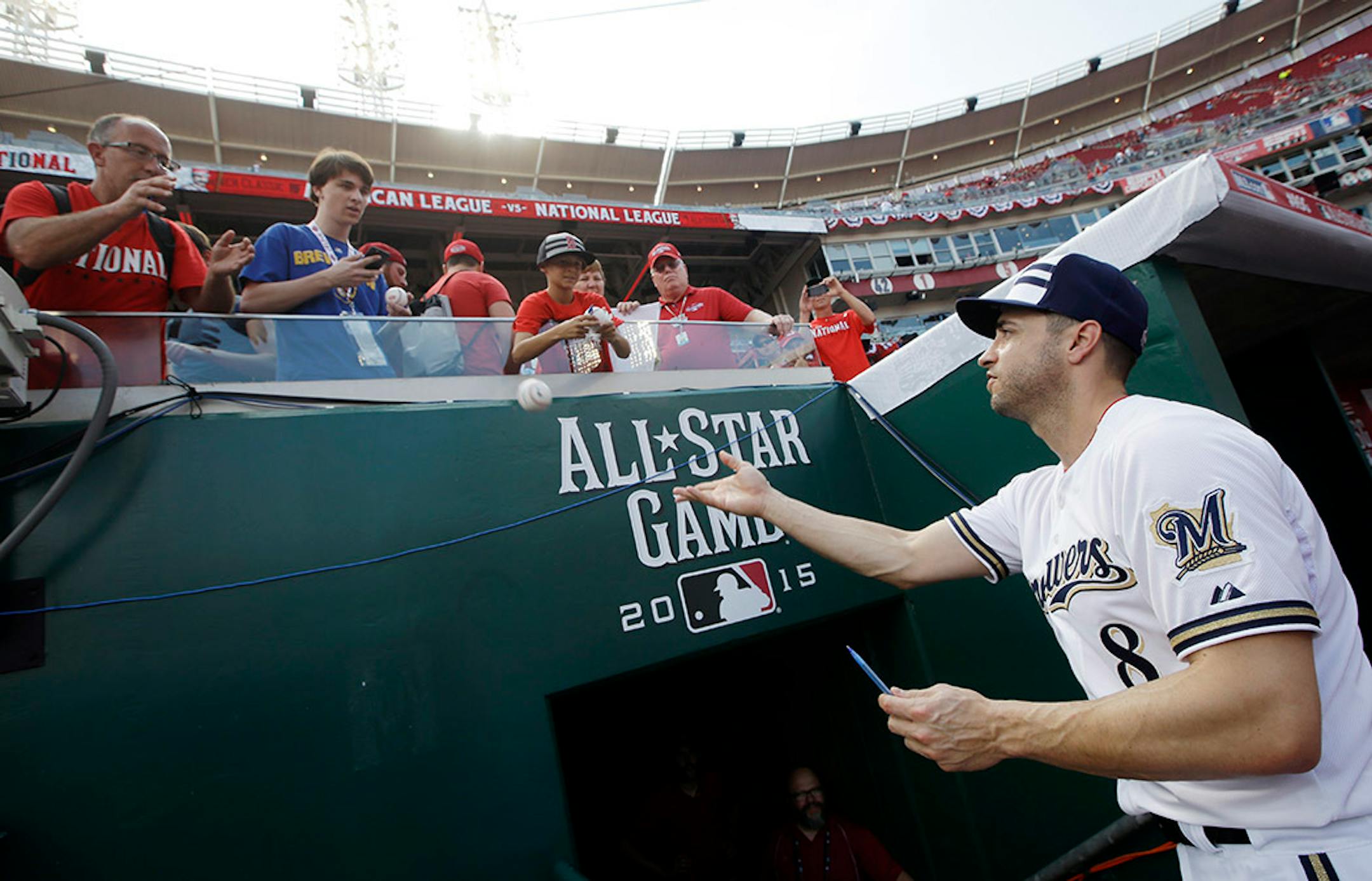 National League's Ryan Braun, of the Milwaukee Brewers, tosses a baseball to a fan before the MLB All-Star baseball game, Tuesday, July 14, 2015, in Cincinnati.