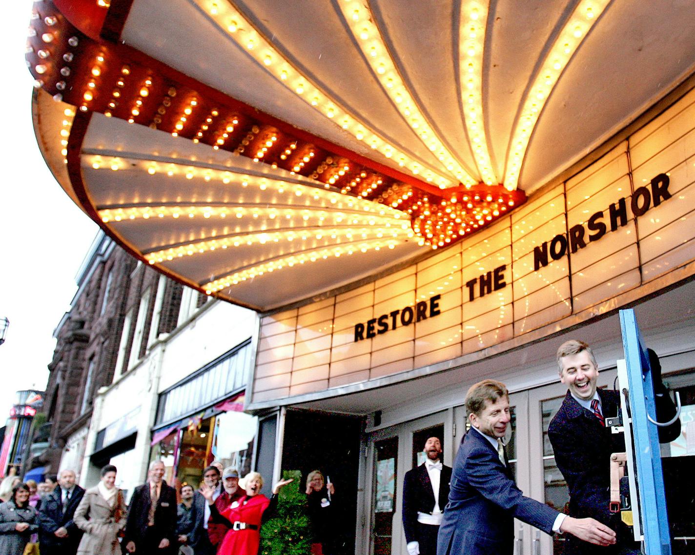 t10.29.2013 -- Steve Kuchera -- kucheraNORSHORE1030 -- Duluth Mayor Don Ness laughs after the NorShor Theatre&#x201a;&#xc4;&#xf4;s marquee lights come on before he and developer George Sherman flipped the switch that was to signal the marquee&#x201a;&#xc4;&#xf4;s lighting Tuesday. The lighting was part of an event celebrated the planned restoration of the building. Steve Kuchera / skuchera@duluthnews.com