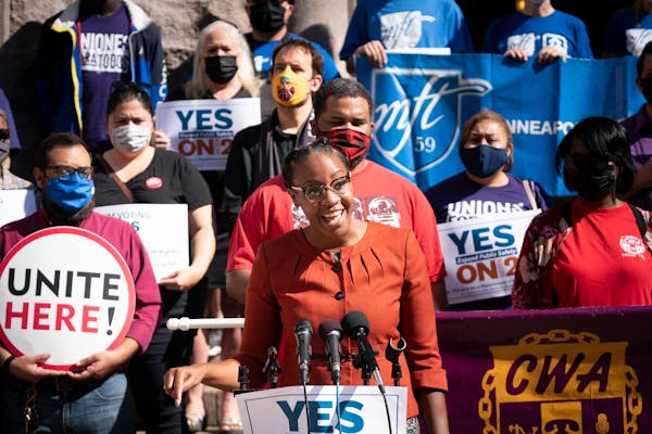 JaNaé Bates, with Yes for Minneapolis, spoke at a podium as she stood with representatives from different unions including the Minneapolis Federation