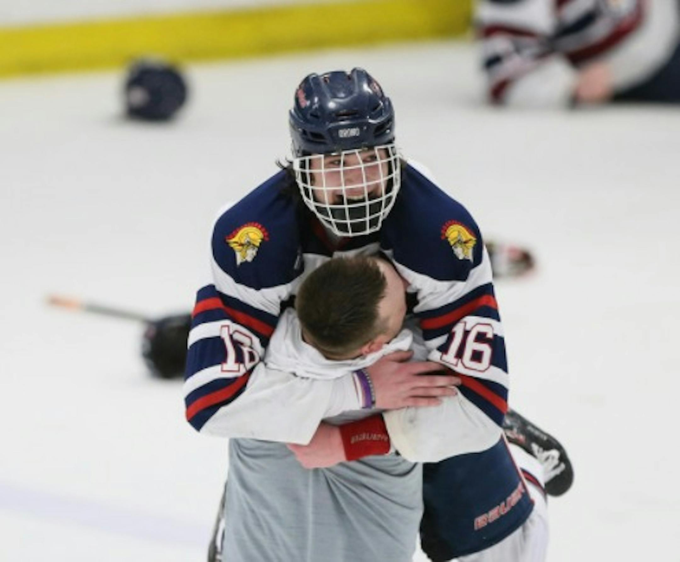 Orono forward Jack Suchy (16) celebrated with coach Will Scholz after their overtime win against Breck School in the 2A section championship in Minneapolis on Thursday, March 1, 2018.