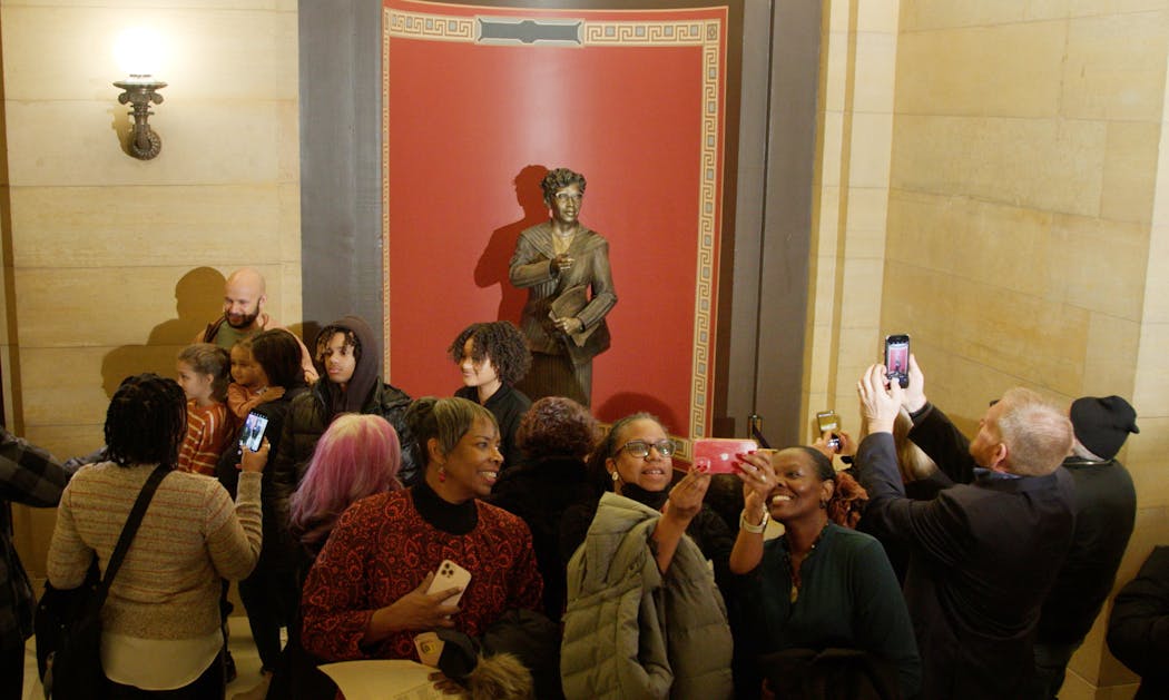 People take photos after a statue of Nellie Stone Johnson was unveiled at the Minnesota State Capitol in St. Paul on Monday.