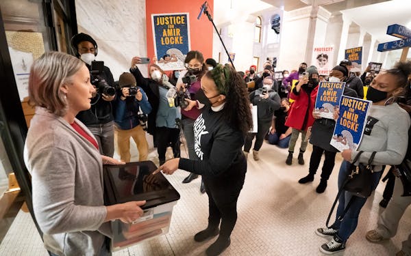 The Rev. Jia Starr Brown, center, handed over signed copies of an ethics complaint against Minneapolis Mayor Jacob Frey to a representative from the C