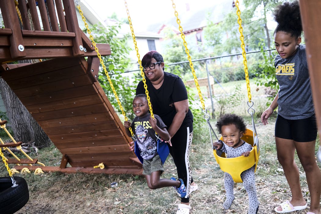 Portia Jackson pushed her son, Nicholas Jackson-Beasley, 6, on the swing with her daughter, ShaiAnne Jackson, 13, and grandson, Knowledge Jackson-Woodard, almost 1, in Jackson’s backyard in Minneapolis’ Old Highland neighborhood. Jackson bought her first home five years ago and now advises aspiring homeowners through her work at PRG.