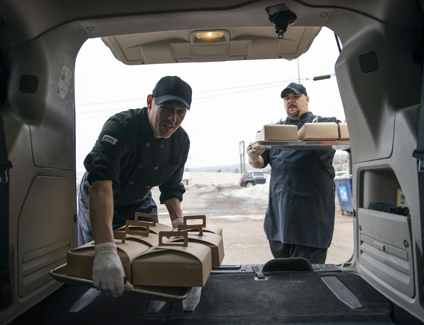 (Left) Jonathan Reznick and Kris Werbelow, owner and kitchen manager of MidCoast Catering, respectively, carried the boxed meals they prepared on Tuesday morning out to their van to be delivered to BeeHive Homes Assisted Living. ]
ALEX KORMANN &#x2022; alex.kormann@startribune.com MidCoast Catering and Yellow Bike coffee shop banded together with a judge to raise $13,000 to deliver meals to healthcare workers. They also put together small packages of food and coffee to bring to local healthcare