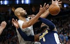 Minnesota Timberwolves' Taj Gibson, left, knocks the ball loose from Denver Nuggets' Paul Millsap during the second half of an NBA basketball game Wed