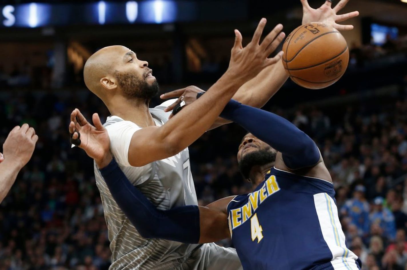 Minnesota Timberwolves' Taj Gibson, left, knocks the ball loose from Denver Nuggets' Paul Millsap during the second half of an NBA basketball game Wednesday, April 11, 2018, in Minneapolis. The Timberwolves won 112-106 in overtime.