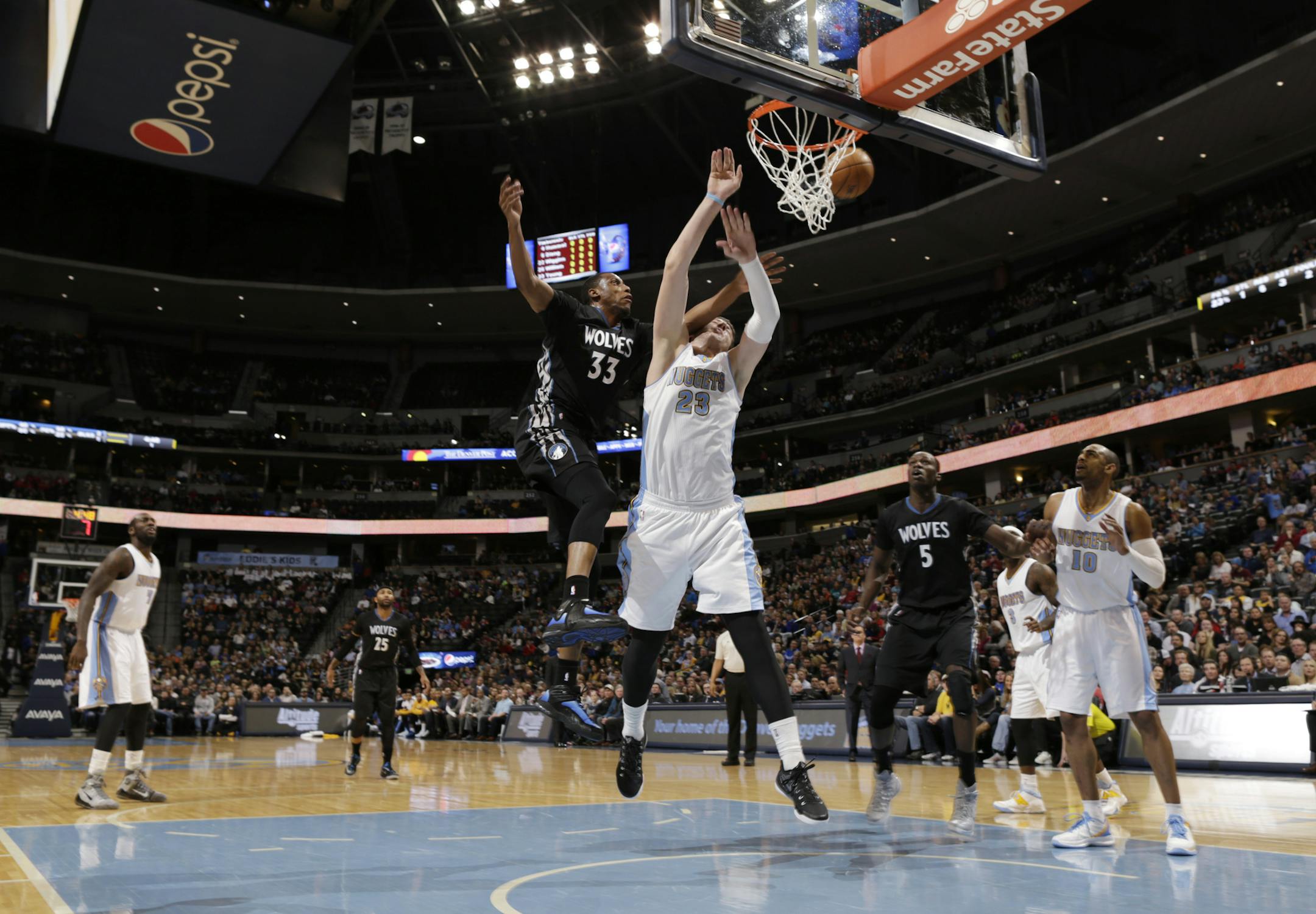 Minnesota Timberwolves forward Thaddeus Young, front left, collides with Denver Nuggets center Jusuf Nurkic while battling for a rebound in the first quarter of an NBA basketball game Saturday, Jan. 17, 2015, in Denver. (AP Photo/David Zalubowski)