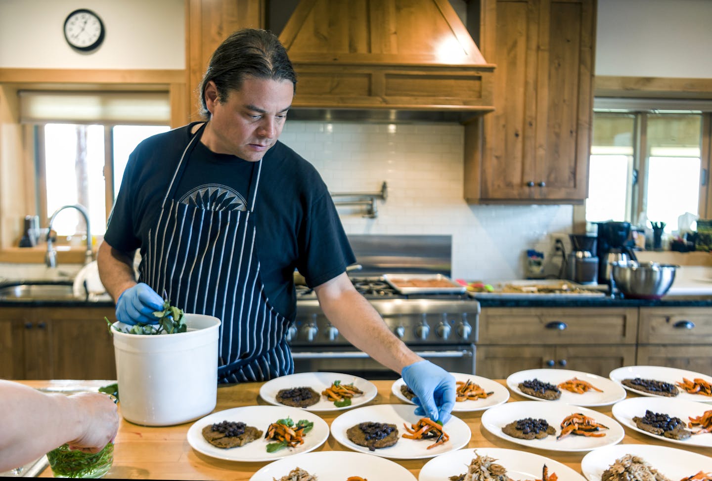 Chef Sean Sherman, who is Oglala Lakota and draws from the knowledge of the Lakota and Ojibwe tribes for his cooking, plating in the kitchen at Coteau des Prairies Lodge near Havana, N.D., July 19, 2016. Sherman's work is part of a slowly gathering movement that he and other cooks are calling &#x201c;new Native American cuisine,&#x201d; or &#x201c;indigenous cuisine&#x201d;-- an effort to revitalize native food cultures in contemporary kitchens. (Dan Koeck/The New York Times)