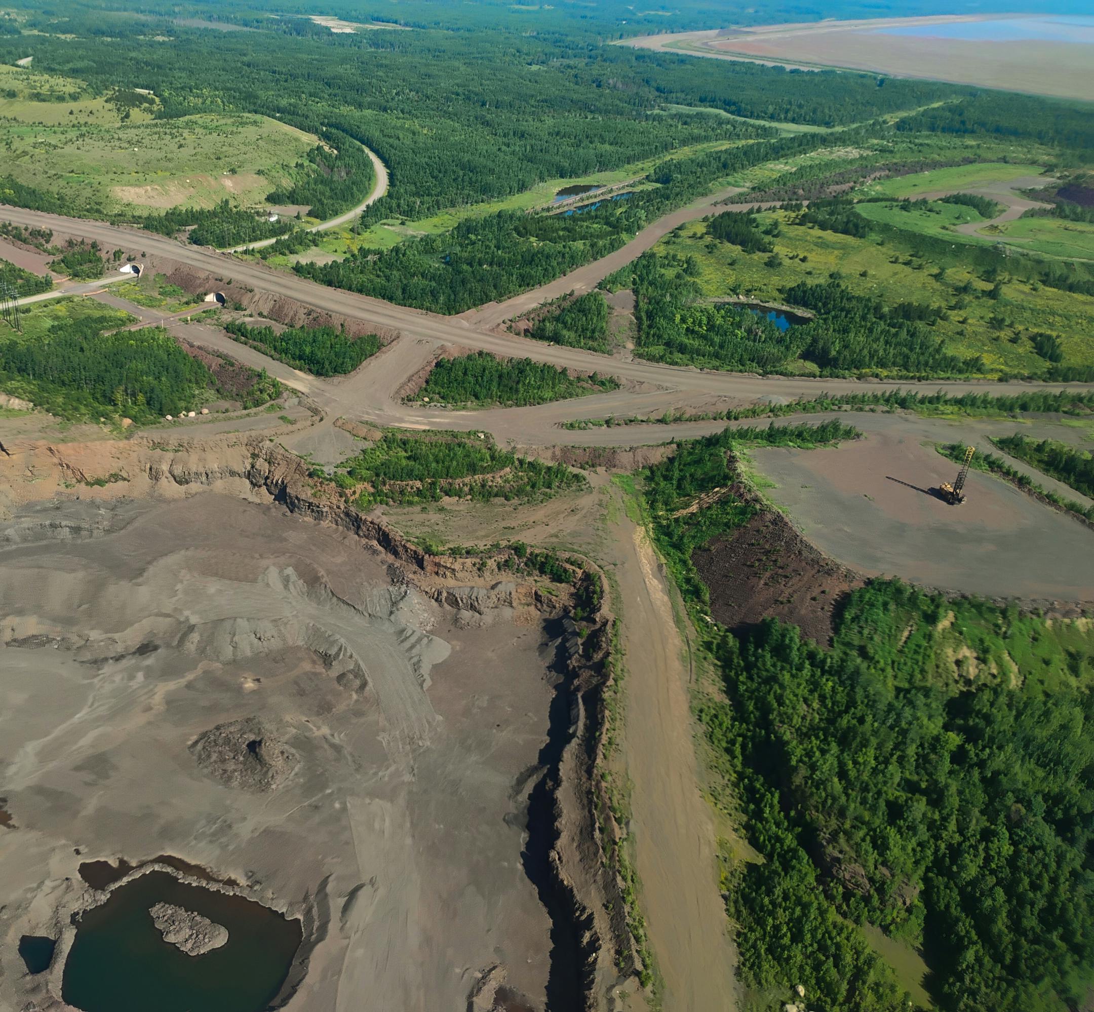 An aerial view of public highways, railroads, tailings basins, pits and dumps.