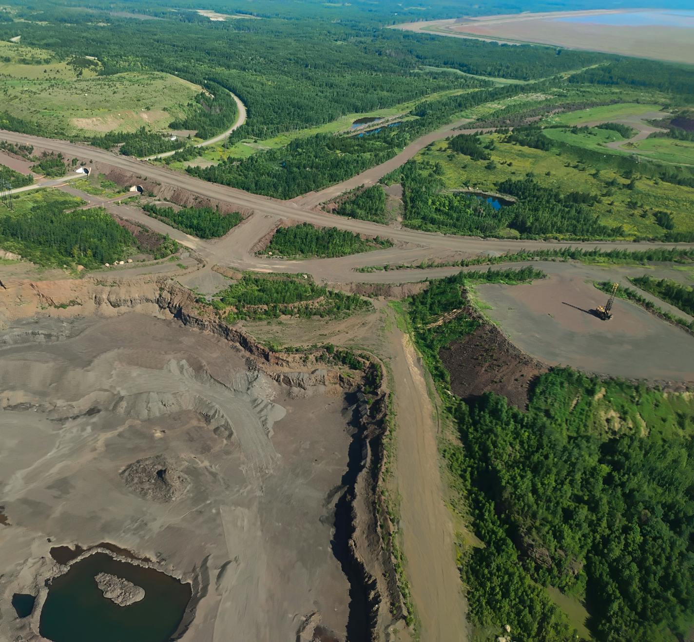 An aerial view of public highways, railroads, tailings basins, pits and dumps.