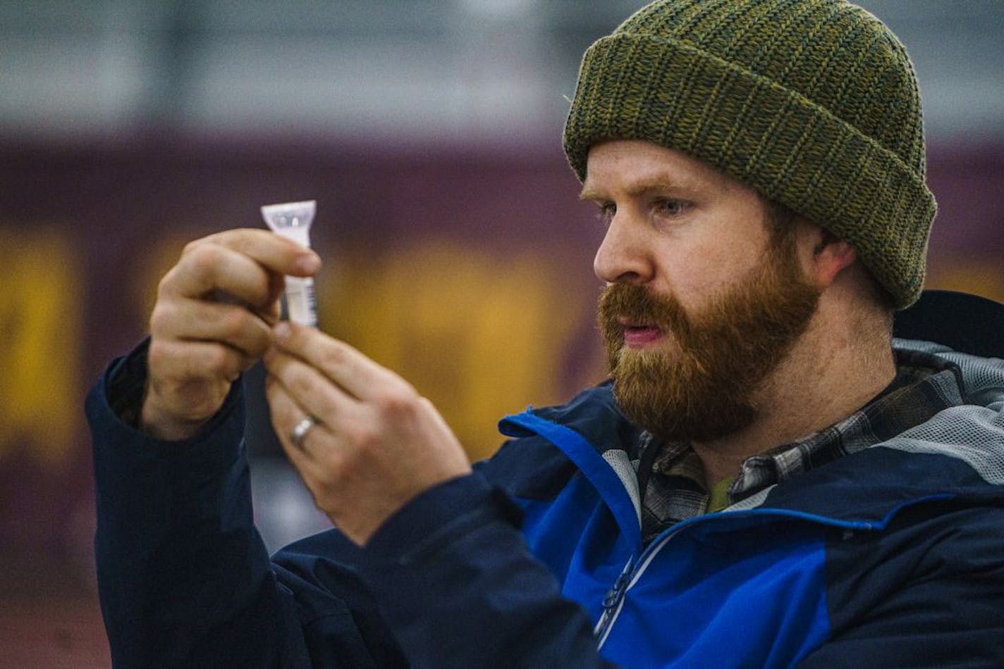 Staffer Nick Hentges spit into a tube for a Covid-19 saliva test. At the U of MN Field House, about 2000 students, staff, and faculty took saliva Covid-19 tests before the university locks down and goes to virtual learning for the rest of the semester.