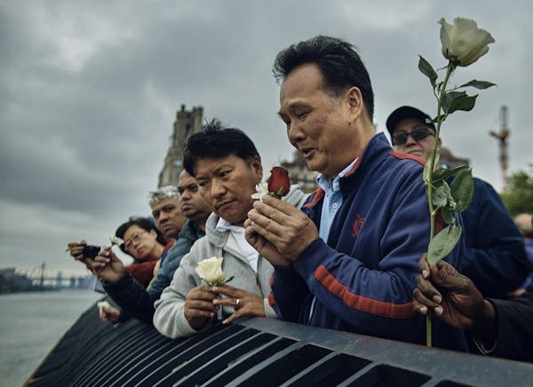 Richard Chow, right, pays homage to his dead brother Yu Mein "Kenny" Chow, along with friends and other family, at the East River, in New York, May 27