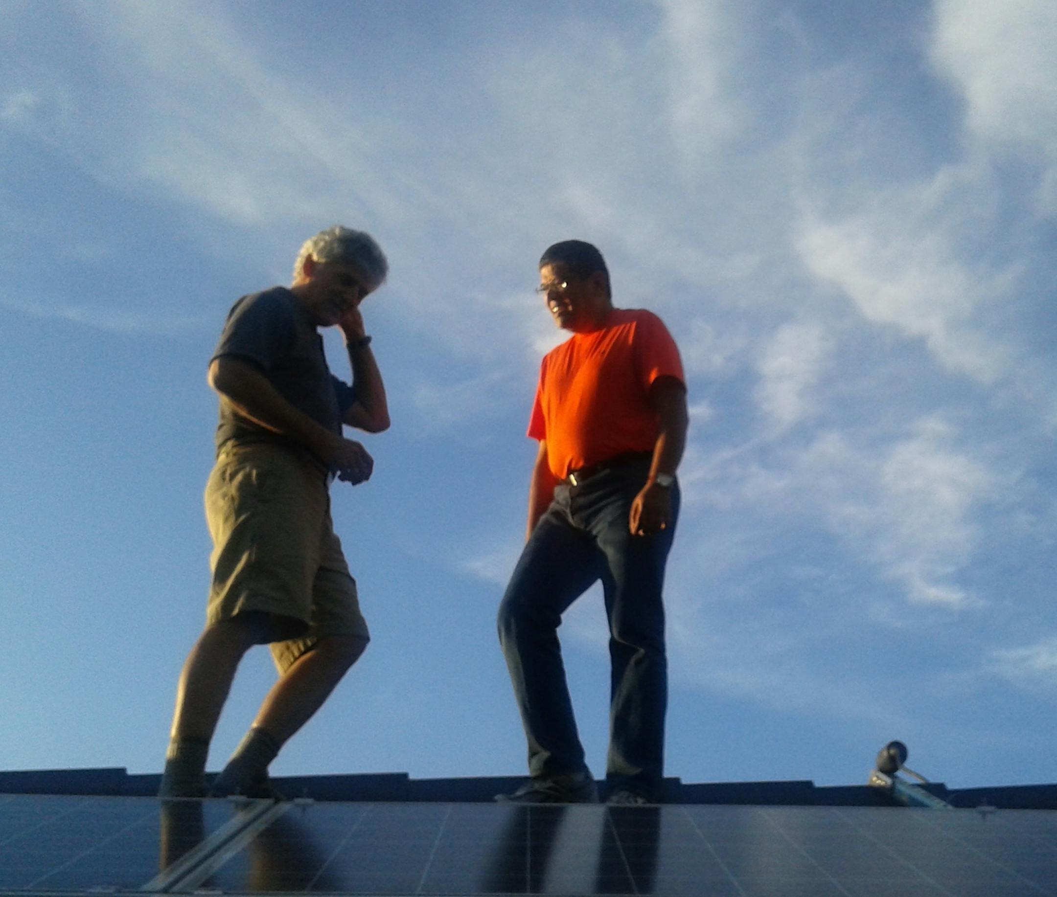Mouli Vaidyanathan, right, and a customer on a California roof installed with a Solar Pod Crown solar array.
