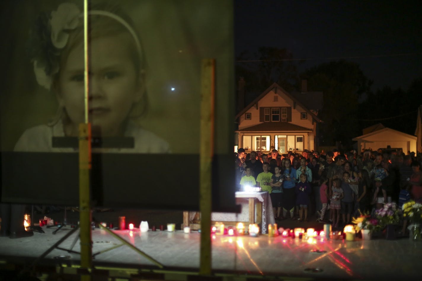 Mourners stood with their lit candles during the prayer vigil for Alayna Ertl on Tuesday night in the parking lot of St. Anthony Church in Watkins, Minn.