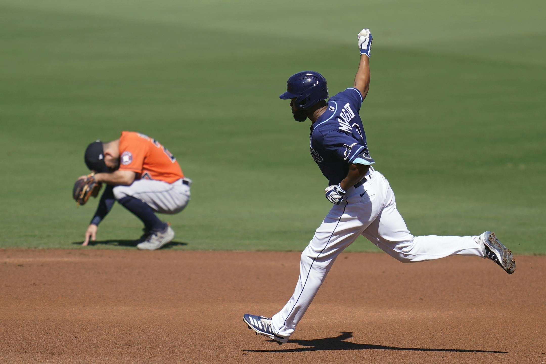 Tampa Bay Rays Manuel Margot rounds the bases past Houston Astros' Jose Altuve after hitting a three run home run against Houston Astros starting pitcher Lance McCullers Jr. during the first inning in Game 2 of a baseball American League Championship Series, Monday, Oct. 12, 2020, in San Diego. (AP Photo/Gregory Bull)