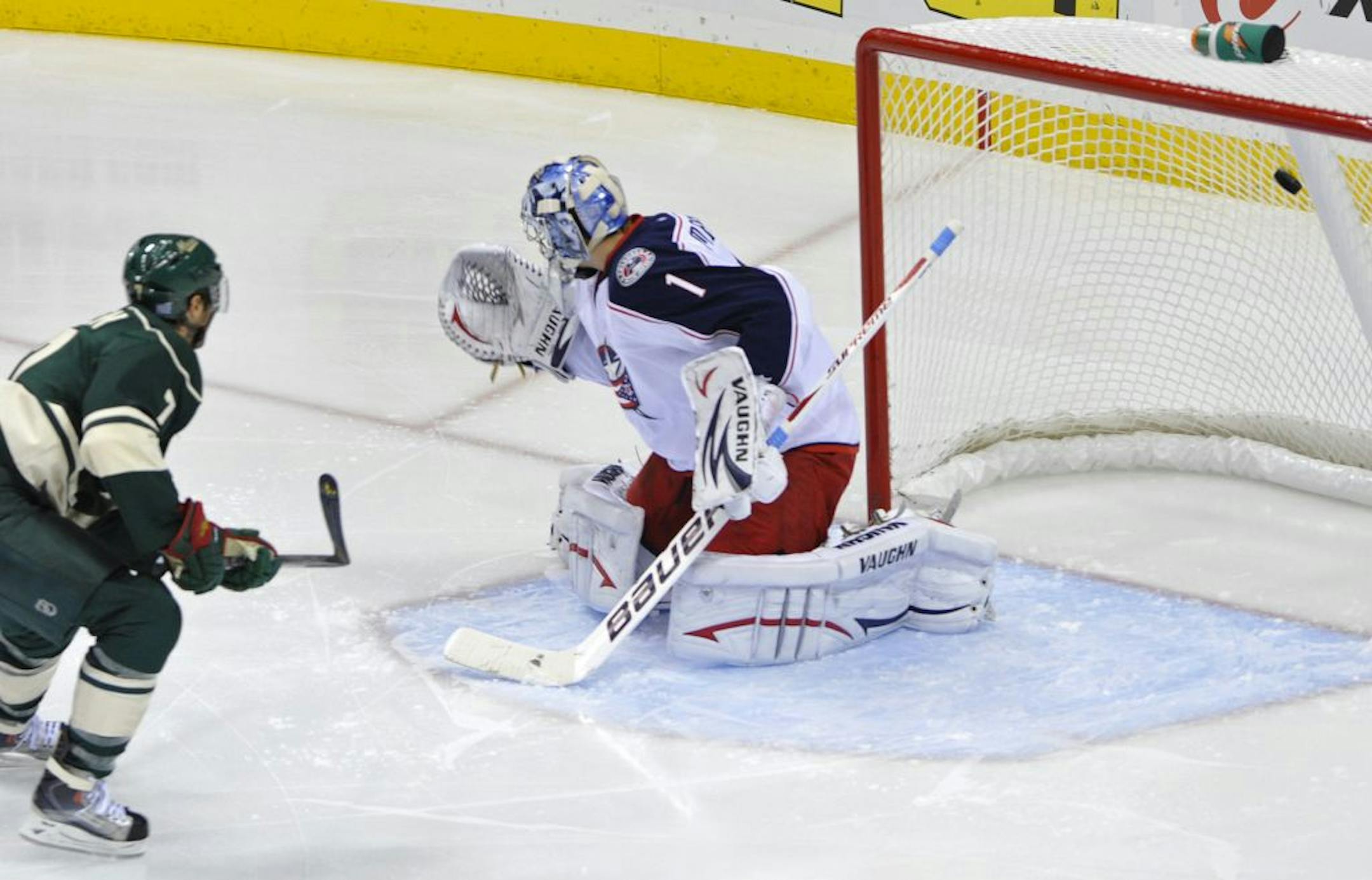 Minnesota Wild's Matt Cullen, left, watches his goal off Columbus Blue Jackets goalie Steve Mason in the first period of an NHL hockey game on Saturday, Oct. 8, 2011, in St Paul, Minn. Mason was replaced in the third period after giving up four goals to the Wild. The Wild won the game 4-2.