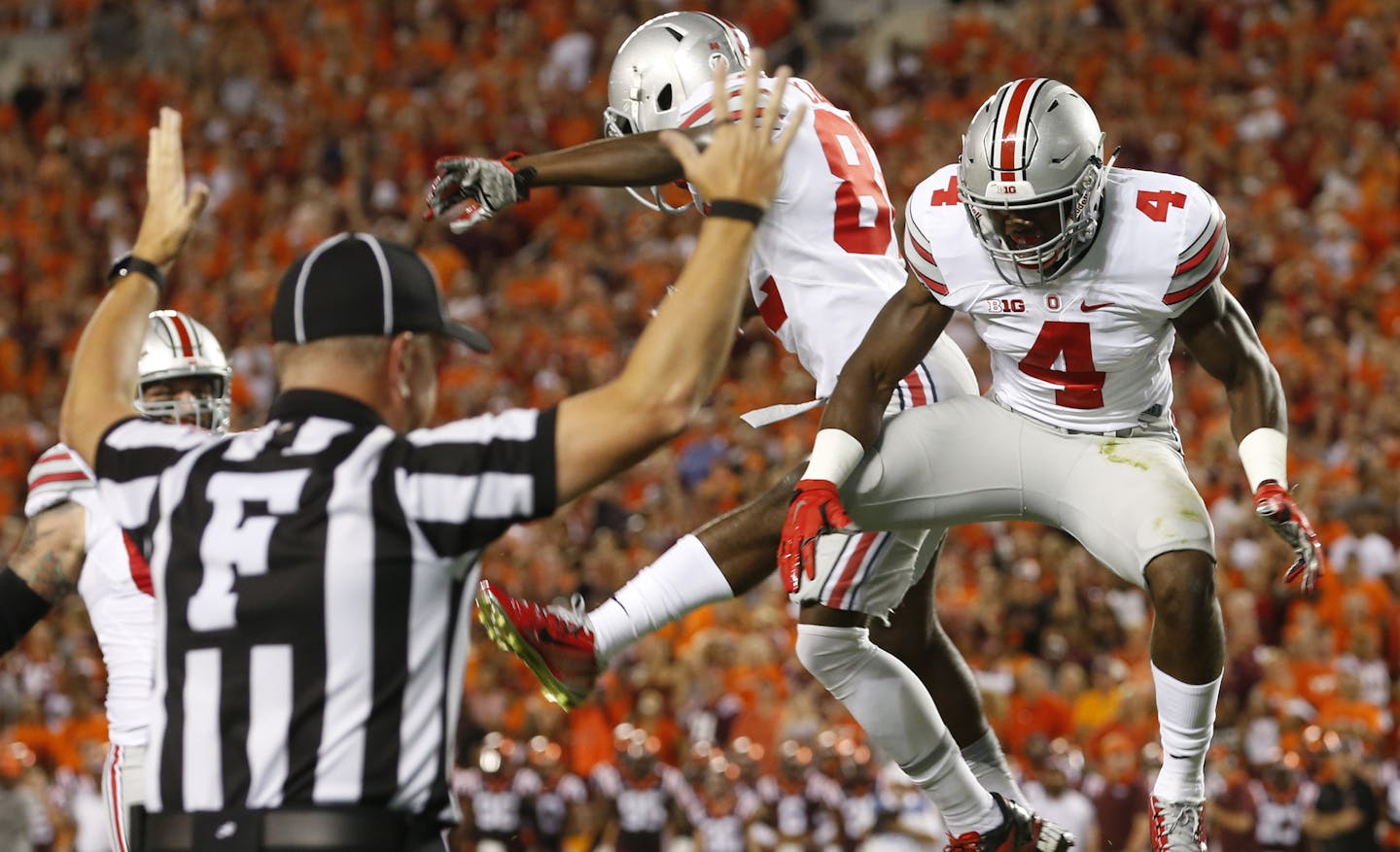 Ohio State running back Curtis Samuel (4) celebrates a touchdown catch with teammate James Clark during the first half of an NCAA college football game against Virginia Tech in Blacksburg, Va., Monday, Sept. 7, 2015. (AP Photo/Steve Helber)