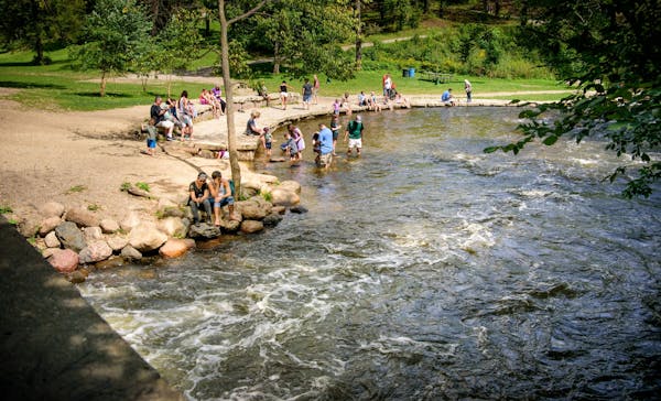 People played in the swiftly moving waters below Minnehaha Falls, Minneapolis.