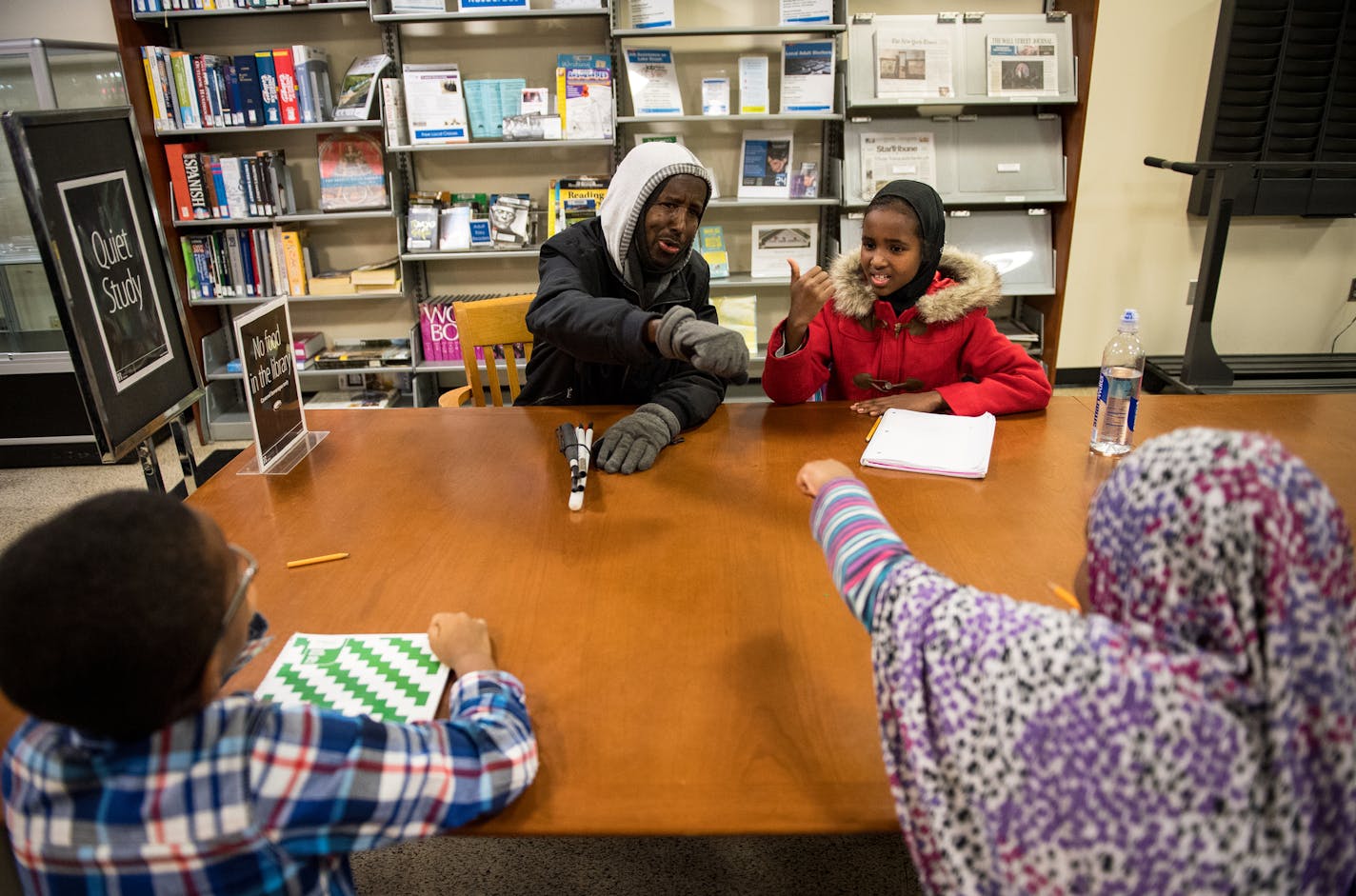 Abdikadir bumped fists with one of his students at the East Lake Library Thursday night. He spends a few hours most weeknights tutoring young Somali kids in mathematics. ] (AARON LAVINSKY/STAR TRIBUNE) aaron.lavinsky@startribune.com Longtime Somali mentor and mathematician, Abdikadir Adan Mohamed "Xiito" is working to push through the challenges of blindness while continuing to help and tutor children in the community with mathematics.