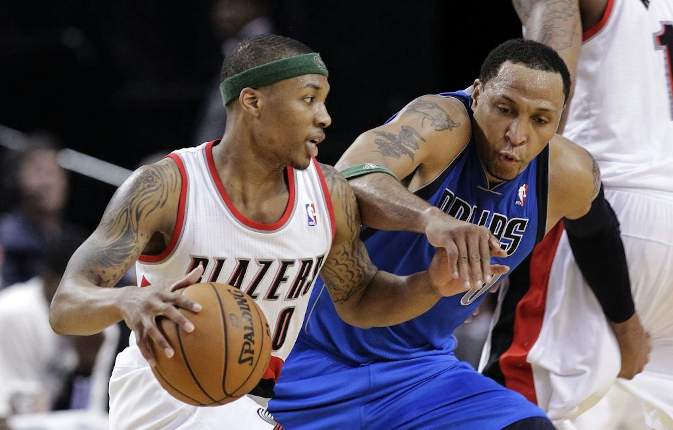 Dallas Mavericks forward Shawn Marion, right, defends against Portland Trail Blazers guard Damian Lillard during the second half of an NBA basketball game in Portland, Ore., Sunday, April 7, 2013. Marion scored 20 points as Dallas won 96-91.