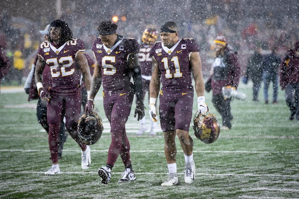 Dejected Gophers players walked off the field after Minnesota's 38-17 loss to Wisconsin in the Battle for Paul Bunyan's Axe at TCF Bank Stadium on Sat