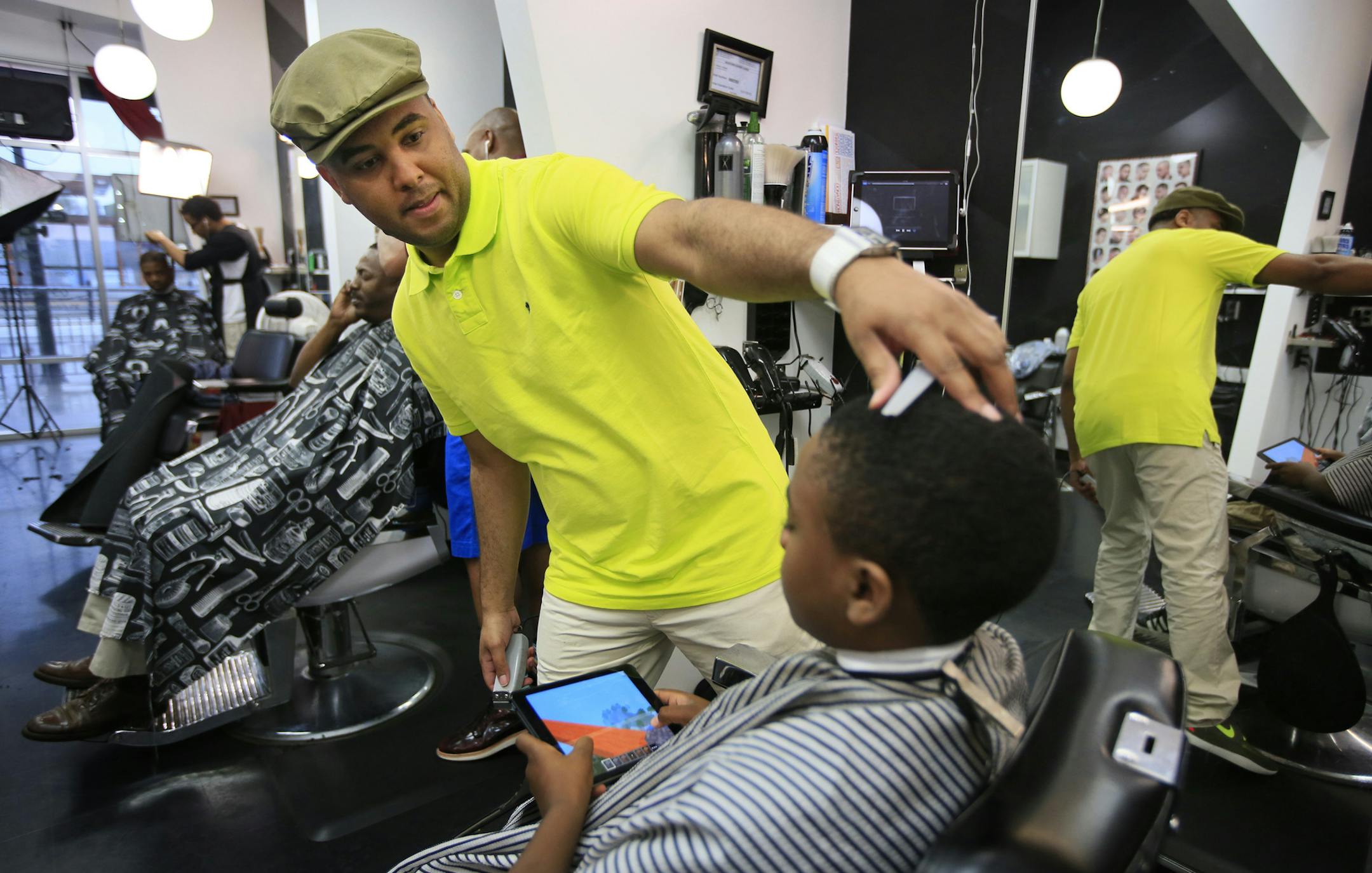 Daymn Johnson expanded his barbershop business with a $30,000 microloan from the Neighborhood Development Center in St. Paul, which specializes in training entrepreneurs in inner-cities. The organization recently won a national award from the Citi Foundation for its work. Here Daymn gives his son Daymn Jr. a haircut. ] BRIAN PETERSON &#x201a;&#xc4;&#xa2; brianp@startribune.com St. Paul, MN - 05/17/2013