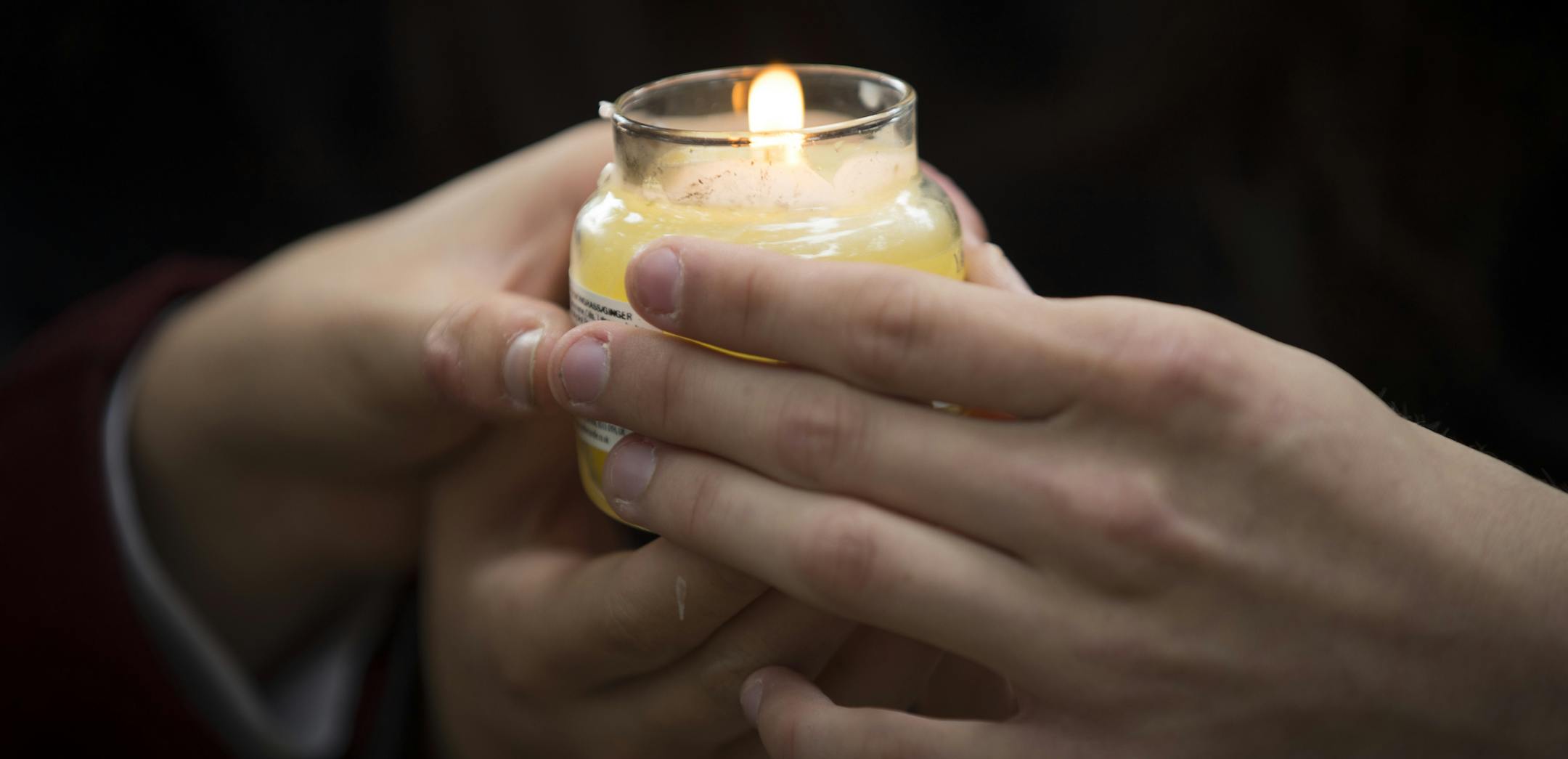 Students hold a candle as they gather for a vigil to commemorate victims of Friday's shooting, outside the Al Noor mosque in Christchurch, New Zealand, Monday, March 18, 2019. Three days after Friday's attack, New Zealand's deadliest shooting in modern history, relatives were anxiously waiting for word on when they can bury their loved ones. (AP Photo/Vincent Thian)