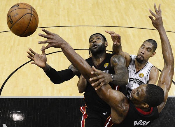 Miami Heat's LeBron James (6), Chris Bosh (1) and San Antonio Spurs' Tim Duncan go after a loose ball during the second half at Game 5 of the NBA Fina