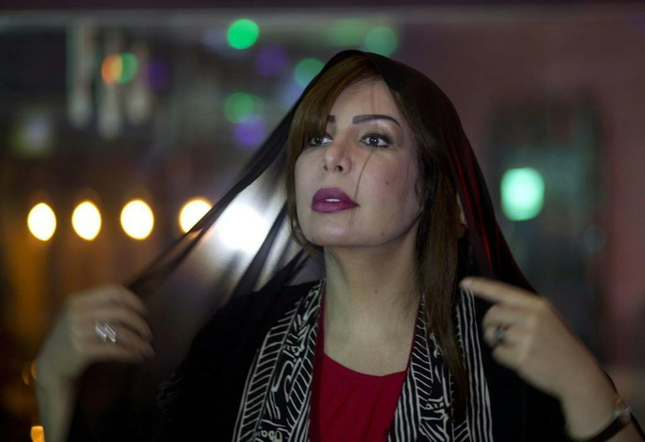 In this Saturday, May 7, 2016 photo, Saudi women's rights activist Souad al-Shammary puts on a head scarf in Jiddah, Saudi Arabia, Saturday, May 7, 2016. Once a devout girl who tended sheep, al-Shammary is a twice-divorced mother of six and Islamic law graduate who is taking on Saudi Arabia�s powerful religious establishment. She is a liberal feminist who roots her arguments in Islam, and has been jailed for her views.