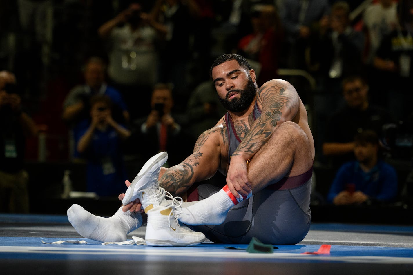 Minnesota's Gable Steveson leaves his shoes on the mat, a sign of retirement in wrestling, after defeating Arizona State's Cohlton Schultz during their heavyweight match in the finals of the NCAA Division I wrestling championships in Detroit, Saturday, March 19, 2022. (Andy Morrison/Detroit News via AP)