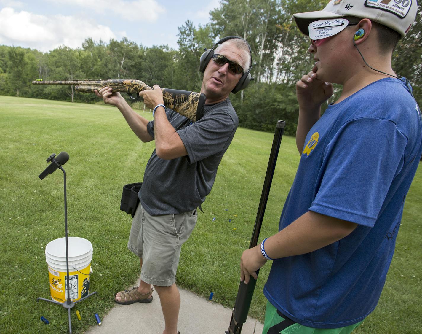 Plymouth Police Officer Dave Groth, left, gets advice from Wayzata High School Trap Team member Barrett Swenson, 14, while shooting trap together. ] (Leila Navidi/Star Tribune) leila.navidi@startribune.com BACKGROUND INFORMATION: The Wayzata High School Trap Team paired up with the Plymouth Police on Tuesday, August 9, 2016 for some friendly trap shooting at the Plymouth Gun Club. In Minnesota, trap shooting is the fastest growing high school sport, with nearly 9,000 students participating in cl