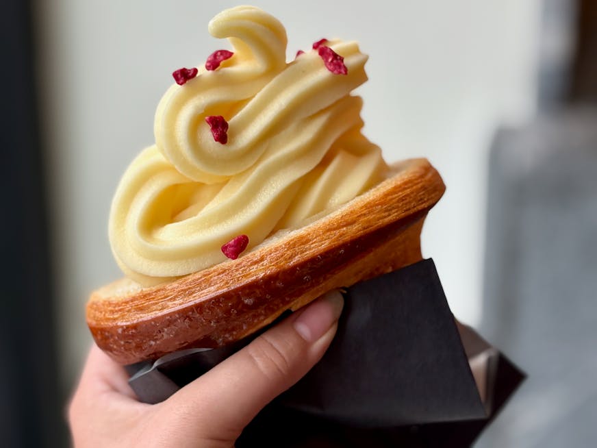 Marc Heu Passionfruit soft serve in half a butter croissant as a cone. Garnished with freeze dried berries.